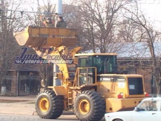 В Ростове вместо подъемника рабочие используют ковш трактора